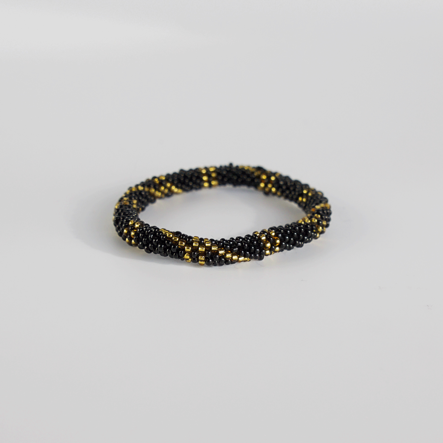 Armbånd med perler i sort og guld