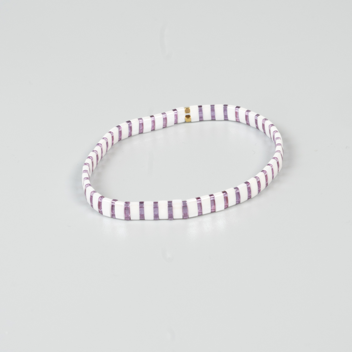 Xia armbånd i lilla og hvid med flade perler i sten fra le mosch