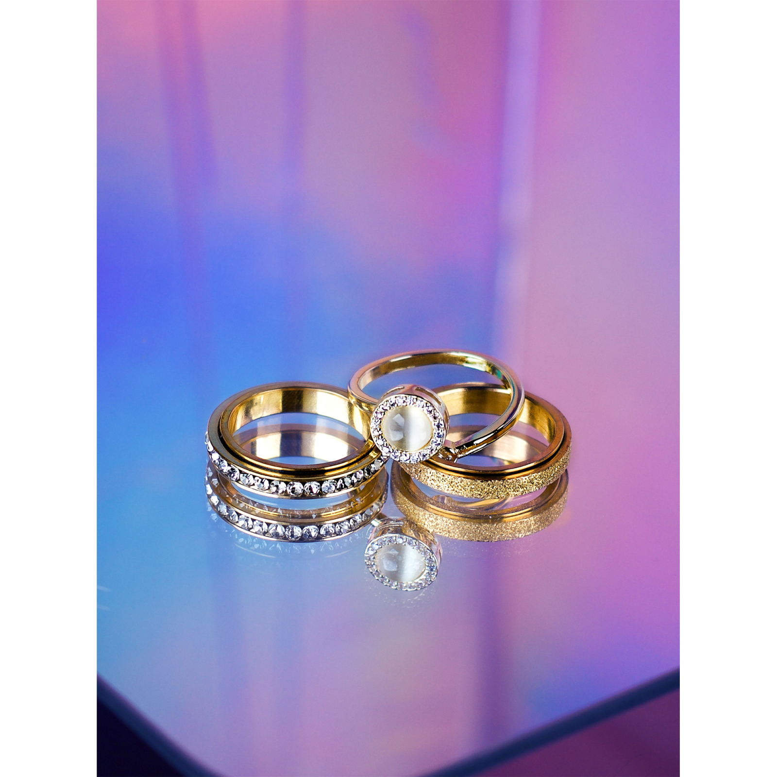 3 anti-stress ringe i guld fra LÉ MOSCH – én med sten og to med drejefunktion.