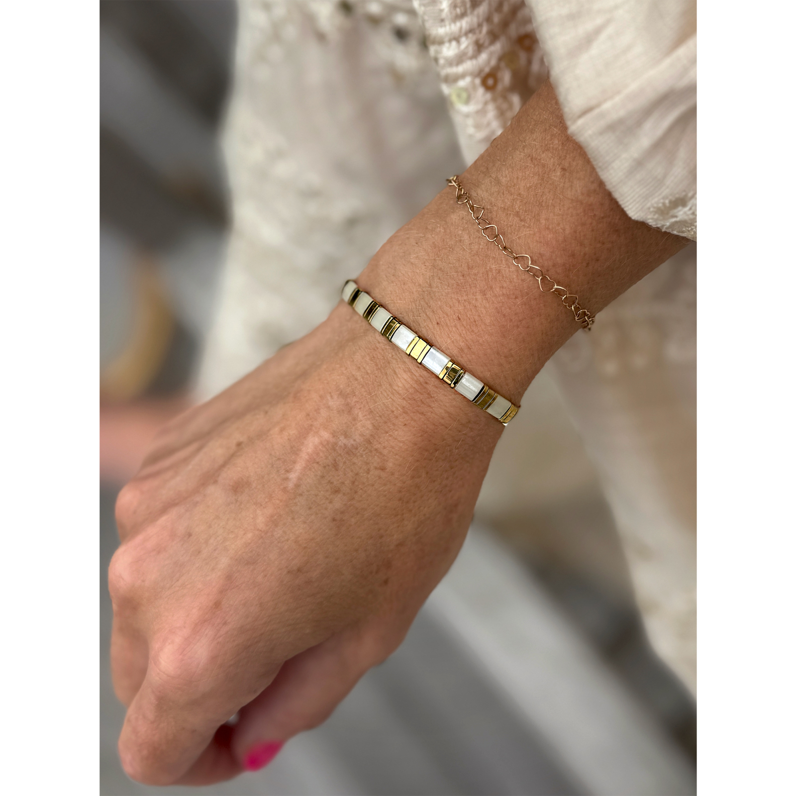 Hvid og guld farvet Xia armbånd fra  LÉ MOSCH – med natursten, vist på hånd.