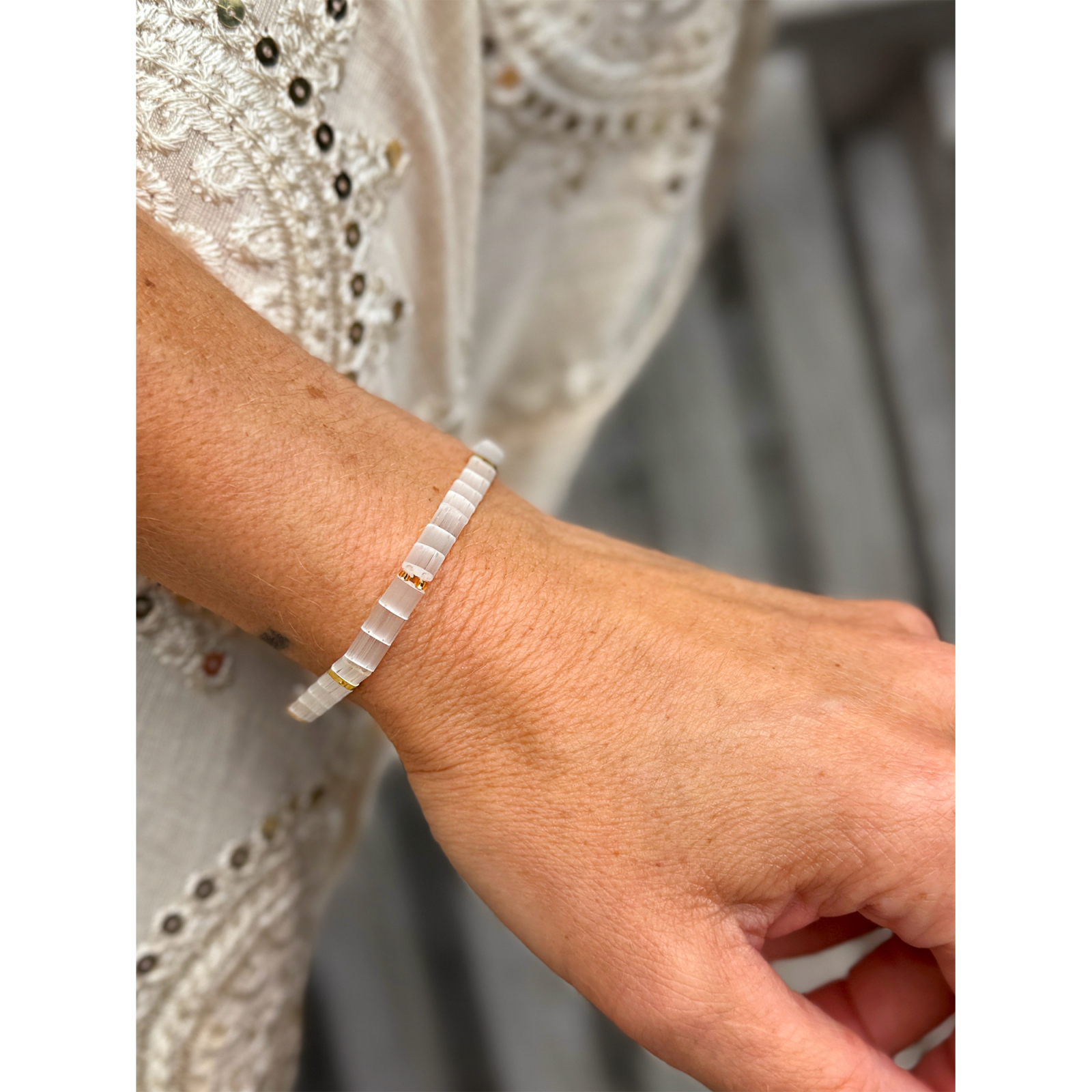 Hvid og guld farvet Xia armbånd fra  LÉ MOSCH – med natursten, vist på hånd.