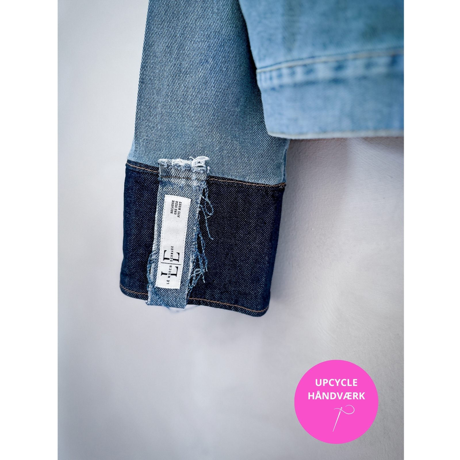 Detaljebillede af mørkeblå frynser og ærme med kontraststof på denimjakke fra le mosch