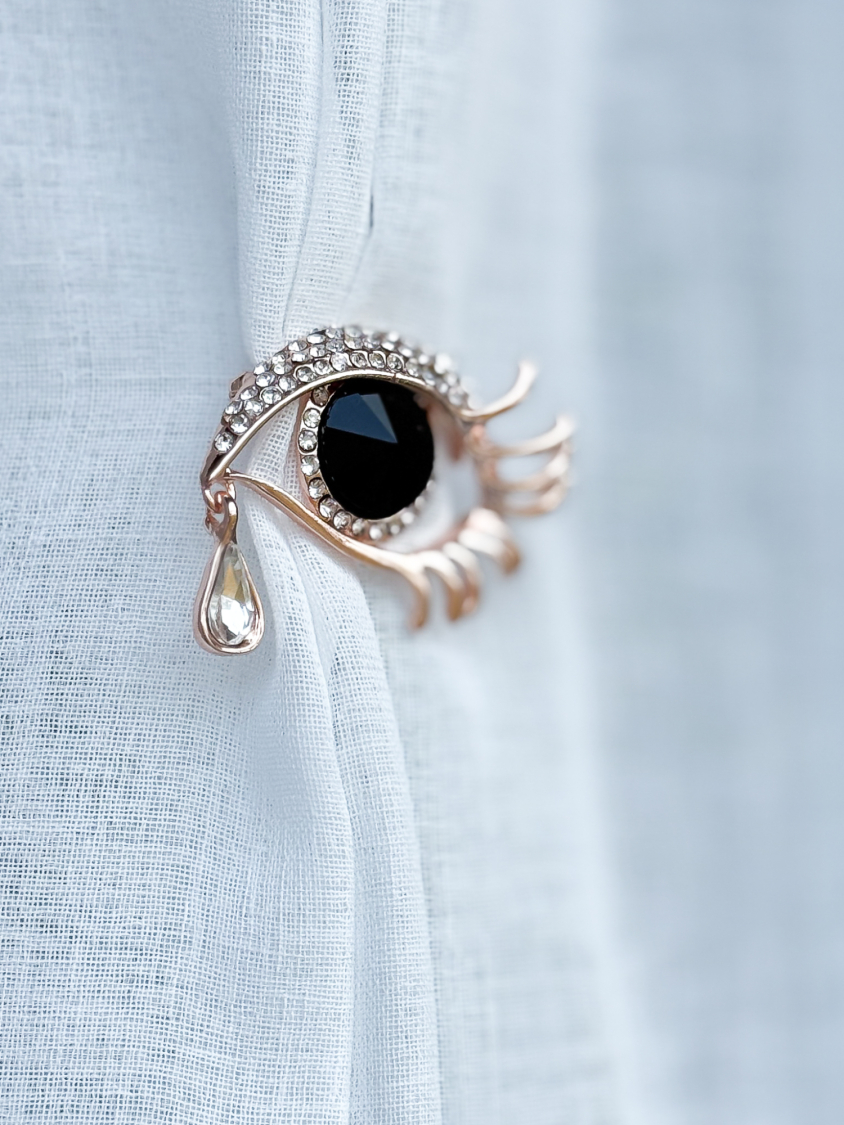 Rosa Gylden Øje Broche med sort sten fra LÉ MOSCH, broche formet som et øje med en tåre, smuk rosa broche med sorte og klare sten,